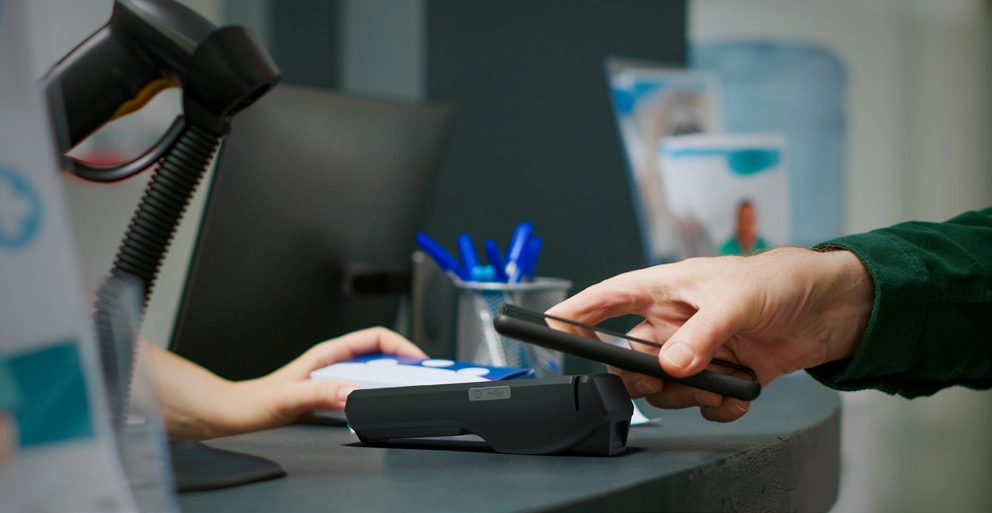 customer making contactless card payment on POS terminal at retail checkout counter