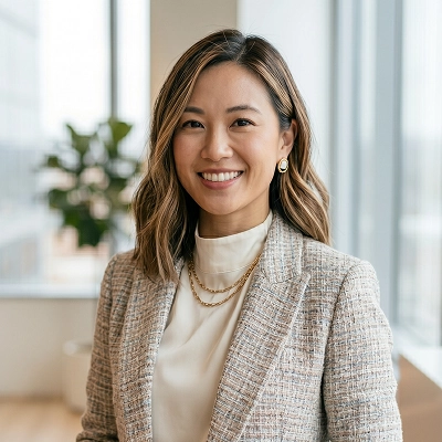 Priya K., a boutique retail owner, smiling in a bright interior setting with soft-focus windows in the background