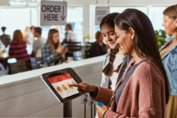 Customer independently placing a food order on a Square self-serve digital kiosk in a quick-service restaurant.