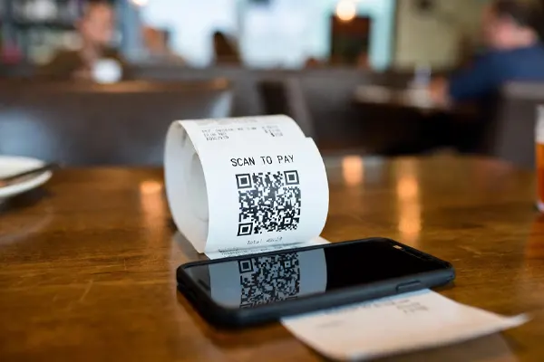 QR code receipt and smartphone on a restaurant table for scan-to-pay checkout and table ordering