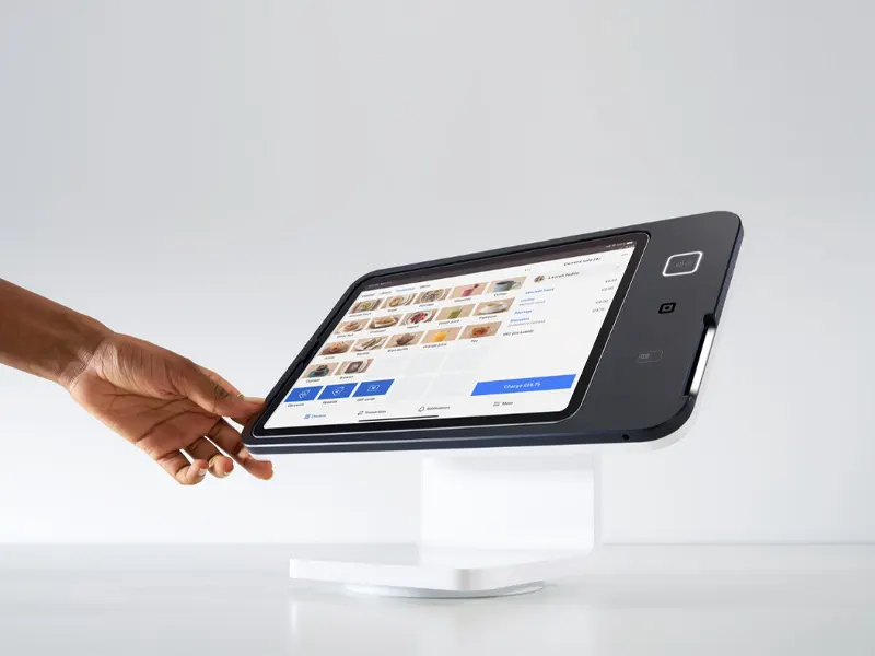 Restaurant customer using Square self-service kiosk and POS system to place order and complete payment at a modern dining counter